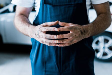 Cropped view of car mechanic standing with clenched handsの写真素材