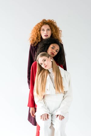 blonde and redhead women standing with african american girl on whiteの写真素材