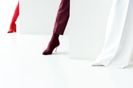 cropped view of stylish women standing in heels on whiteの写真素材