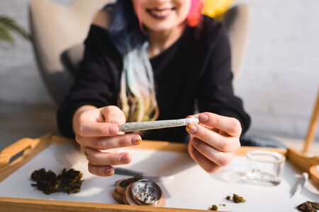 Cropped view of girl presenting joint with medical cannabisの写真素材