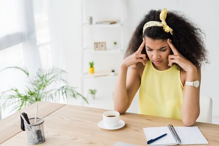 exhausted curly brunette african american woman having headacheの写真素材