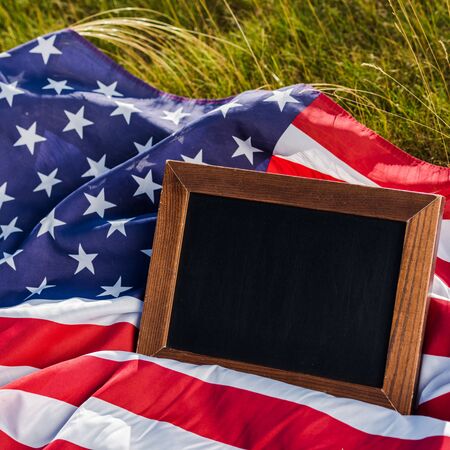 close up of empty chalkboard on american flag with stars and stripesの写真素材