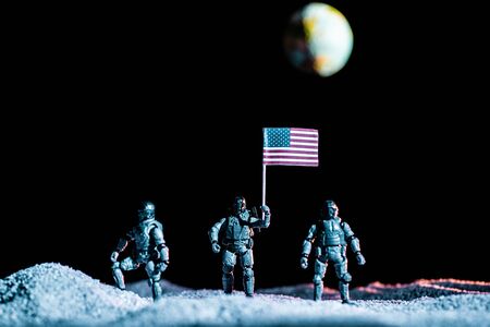 toy soldiers standing with usa flag on planet in space on black background with planet Earthの写真素材