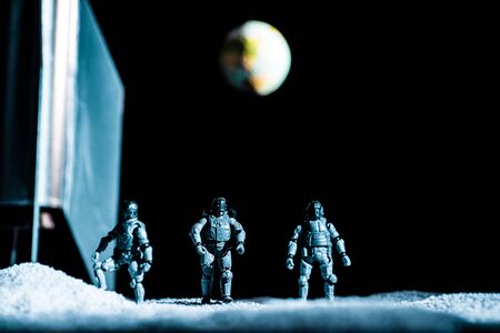 toy soldiers standing in space on black background with planet earthの写真素材