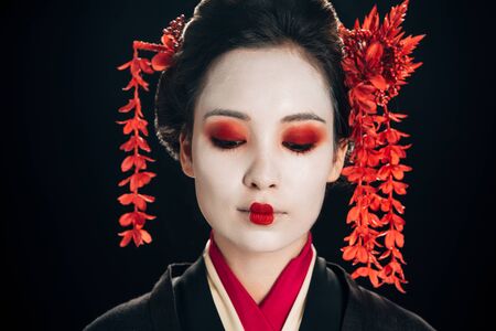portrait of beautiful geisha with flowers in hair isolated on blackの写真素材