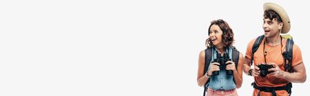 panoramic shot of two young tourists smiling while looking away isolated on grey backgroundの写真素材