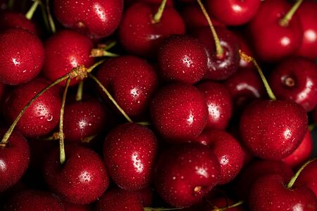 top view of red delicious and ripe cherries with water drops
