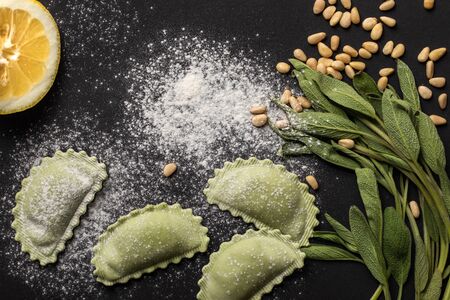 top view of raw green ravioli with pine nuts, flour, green sage and lemonの写真素材