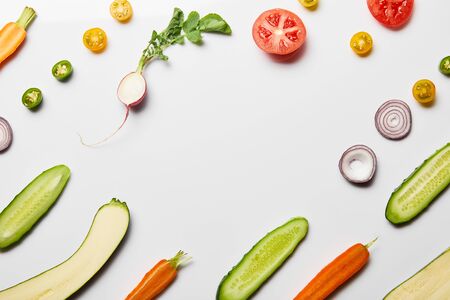 top view of fresh sliced vegetables on white background with copy spaceの写真素材