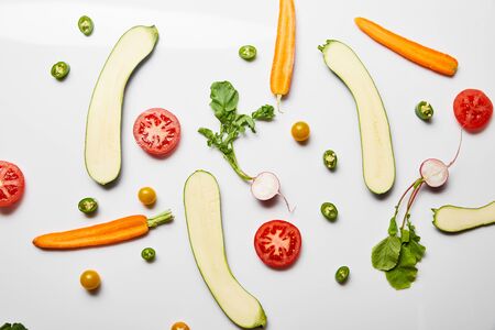 top view of fresh vegetable slices on white backgroundの写真素材