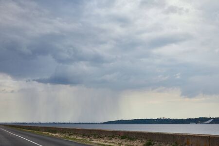 overcast view of sky upon highway and forest coast