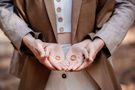 cropped view of stylish couple holding wedding ringsの写真素材