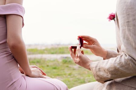 cropped view of bridegroom holding box with wedding ring and making proposal