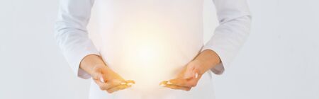 panoramic shot of healer standing and gesturing near light isolated on whiteの写真素材