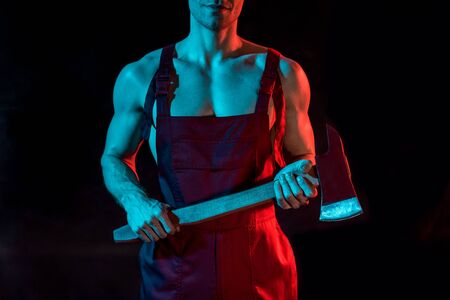 cropped view of shirtless fireman holding flat head axe on blackの写真素材
