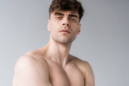 serious shirtless sexy muscular man looking at camera isolated on greyの写真素材