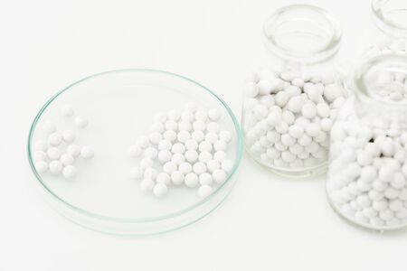 selective focus of bottles with medicine near petri dish isolated on whiteの写真素材