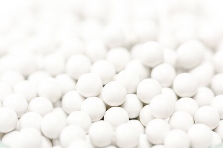 textured background made with of small white round pillsの写真素材