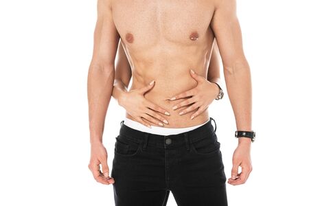 partial view of girl embracing shirtless boyfriend with nipple piercing isolated on whiteの写真素材
