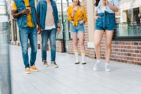cropped view of multicultural men and girls standing together near buildingの写真素材