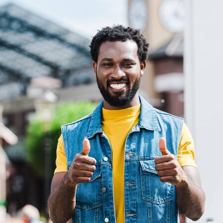happy african american man showing thumbs up while looking at camera