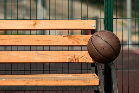 brown basketball ball on wooden bench at basketball courtの写真素材