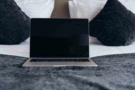 laptop with blank screen on bed in hotel roomの写真素材