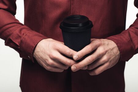 cropped view of man holding black disposable cup isolated on greyの写真素材
