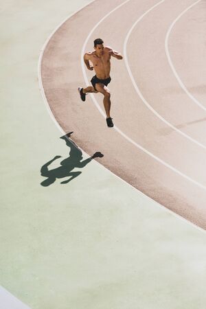 overhead view of mixed race sportsman running at stadiumの写真素材
