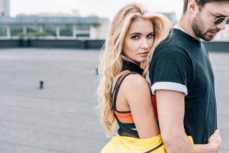 blonde and attractive woman hugging handsome man in glasses
