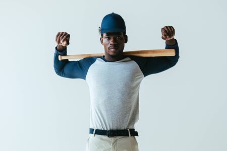 confident african american sportsman with baseball bat looking at camera isolated on greyの写真素材