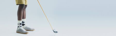 partial view of african american sportsman playing golf on grey background, panoramic shot