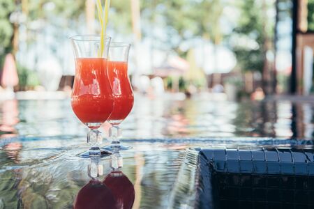 two glasses with natural, delicious refreshing beverage at poolsideの写真素材