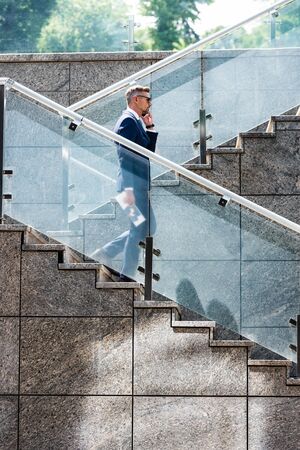 handsome businessman in suit and glasses talking on smartphone