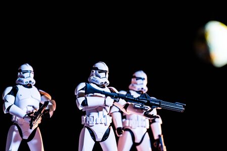 KYIV, UKRAINE - MAY 25, 2019: white imperial stormtroopers with guns on black background with blurred planet Earthのeditorial素材