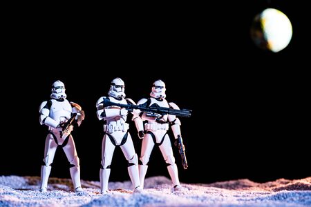 KYIV, UKRAINE - MAY 25, 2019: white imperial stormtroopers with guns in space on black background with planet Earthのeditorial素材