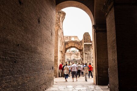 ROME, ITALY - JUNE 28, 2019: full length view of group of tourists walking near ancient buildings