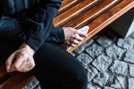 selective focus of woman holding handkerchief while sitting on bench