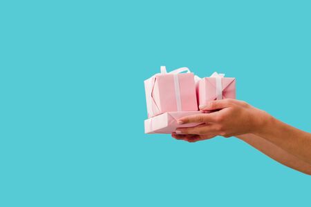cropped view of girl holding presents in hands isolated on blue