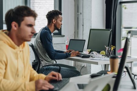 selective focus of two young multicultural programmers working in office togetherの写真素材
