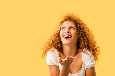 cheerful woman with red hair, isolated on yellow