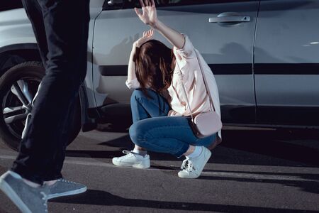 thief attacking woman near car at nighttimeの写真素材