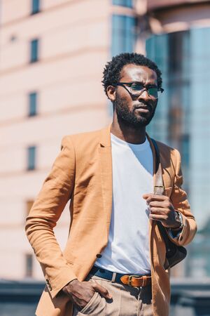 confident african american businessman holding hand in pocket and looking awayの写真素材