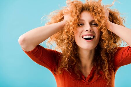 portrait of excited redhead girl isolated on blue