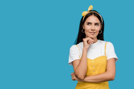 pensive young woman in headband isolated on blueの写真素材