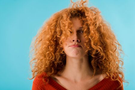 portrait of beautiful redhead young woman isolated on blueの写真素材