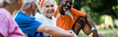 panoramic shot of cheerful multicultural men and women in sportswear