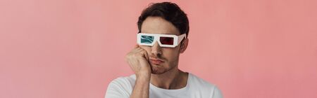 panoramic shot of bored young man in 3d glasses propping face with hand isolated on pink