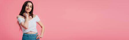 beautiful smiling girl posing with hand on hip isolated on pink, panoramic shot