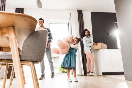 low angle view of african american family walking into house while holding different stuffの写真素材